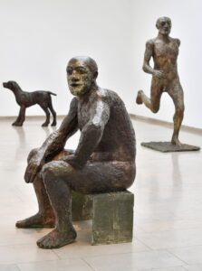Elisabeth Frink, Seated Man II, 1986, Bronze bemalt, dem Yorkshire Sculpture Park auf Wunsch von Lin Jammet, dem verstorbenen Sohn der Künstlerin, gestiftet; Elisabeth Frink, Large Dog, 1986, Bronze, Freundliche Leihgabe von Dorset County, Hospital Charity; Elisabeth Frink, Running Man, 1986, Bronze, Victoria Gallery & Museum, University of Liverpool