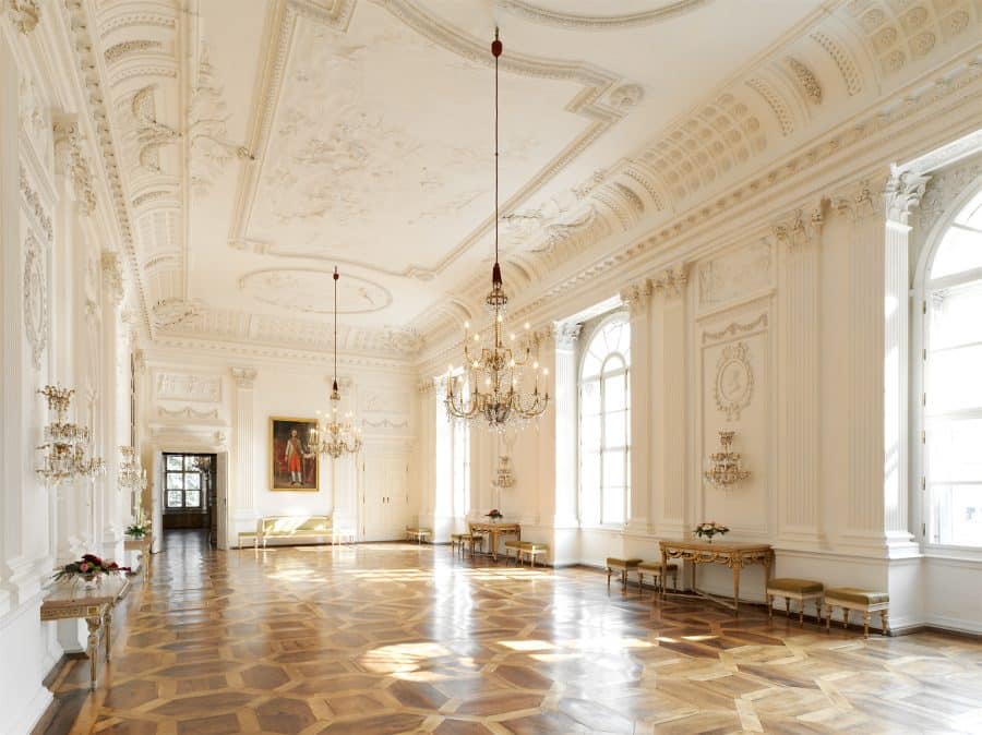 Hieronymus Graf von Colloredo, der letzte Fürsterzbischof vor der Säkularisation ließ die Wände der Prunkräume gemäß dem klassizistischen Zeitgeschmack durch den Hofstuckateur Peter Pflauder mit feiner Ornamentik in Weiß und Gold ausgestalten. Aus den 1770er und 1780er Jahren stammen auch die erhaltenen frühklassizistischen Kachelöfen in den Prunkräumen, die die älteren Exemplare aus der Harrach-Zeit ersetzten. Der Weißer Saal (Marcus-Sitticus-Saal), Residenz zu Salzburg © SBSB