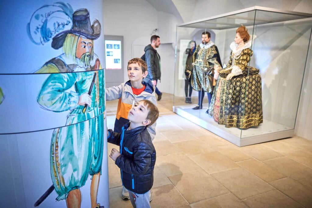 Nils (4) und Lars (7) aus Bützow (Mecklenburg-Vorpommern) probieren das neue Figurenkarussell im Vorraum der Hofestube der Georgenburg aus. © Marko Förster/Festung Königstein gGmbH