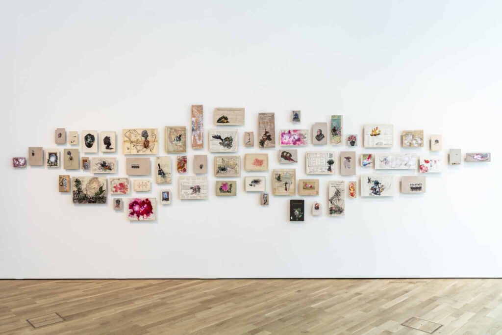 Firelei Báez, Those who would douse it (it does not disturb me to accept that there are places where my identity is obscure to me, and the fact that it amazes you does not mean I relinquish it), 2018, Acryl, Tinte und Chincollé auf 58 herausgetrennten Buchseiten, 244 x 569 cm (Maße variabel), Kunstmusem Wolfsburg, © Firelei Báez, Courtesy die Künstlerin und James Cohan Gallery, Foto: Marek Kruszewski